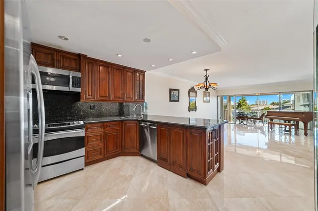 a kitchen with stainless steel appliances granite countertop a refrigerator and a stove top oven