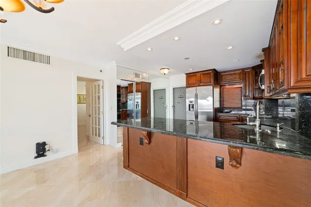 a view of a kitchen with stainless steel appliances granite countertop a refrigerator and a sink