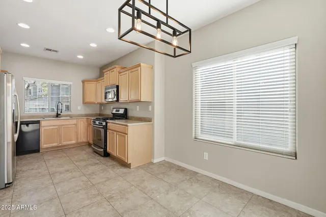 a kitchen with stainless steel appliances granite countertop a refrigerator and a stove top oven