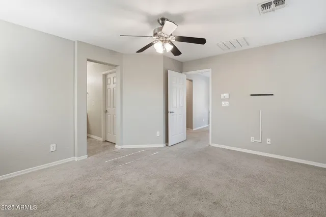 an empty room with chandelier fan