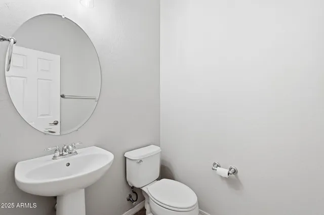 a bathroom with a granite countertop sink toilet and a mirror