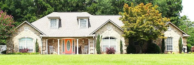 a view of a white house with a big yard and large tree
