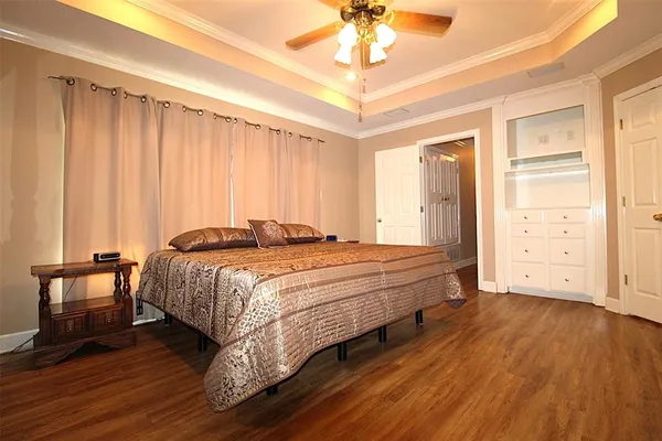 a spacious bedroom with a bed and a chandelier