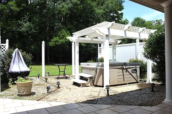 a view of house with patio outdoor seating and covered with trees in the background
