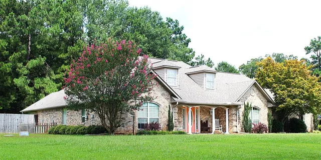 a view of house with a yard