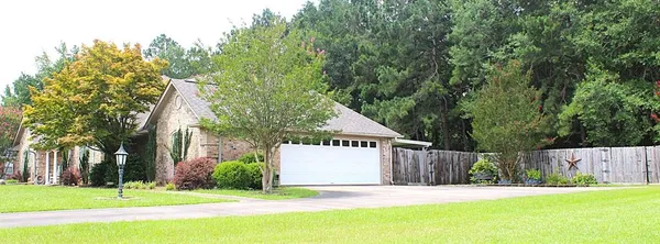 a front view of a house with a yard and trees