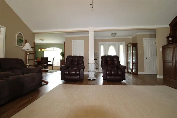 a living room with furniture and a large mirror with wooden floor