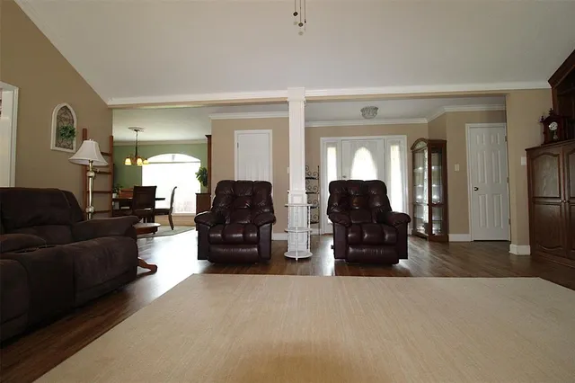 a living room with furniture and a large mirror with wooden floor