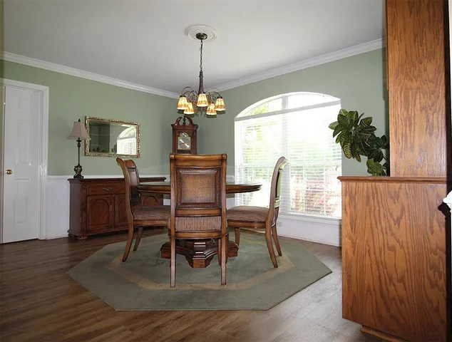 a dining room with furniture a chandelier and wooden floor