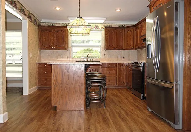 a kitchen with wooden floors and wooden cabinets