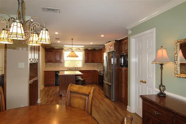 a kitchen with refrigerator a sink and chairs