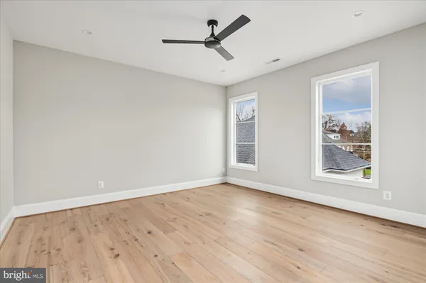 an empty room with a window and ceiling fan