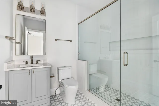 a bathroom with a toilet sink vanity and mirror