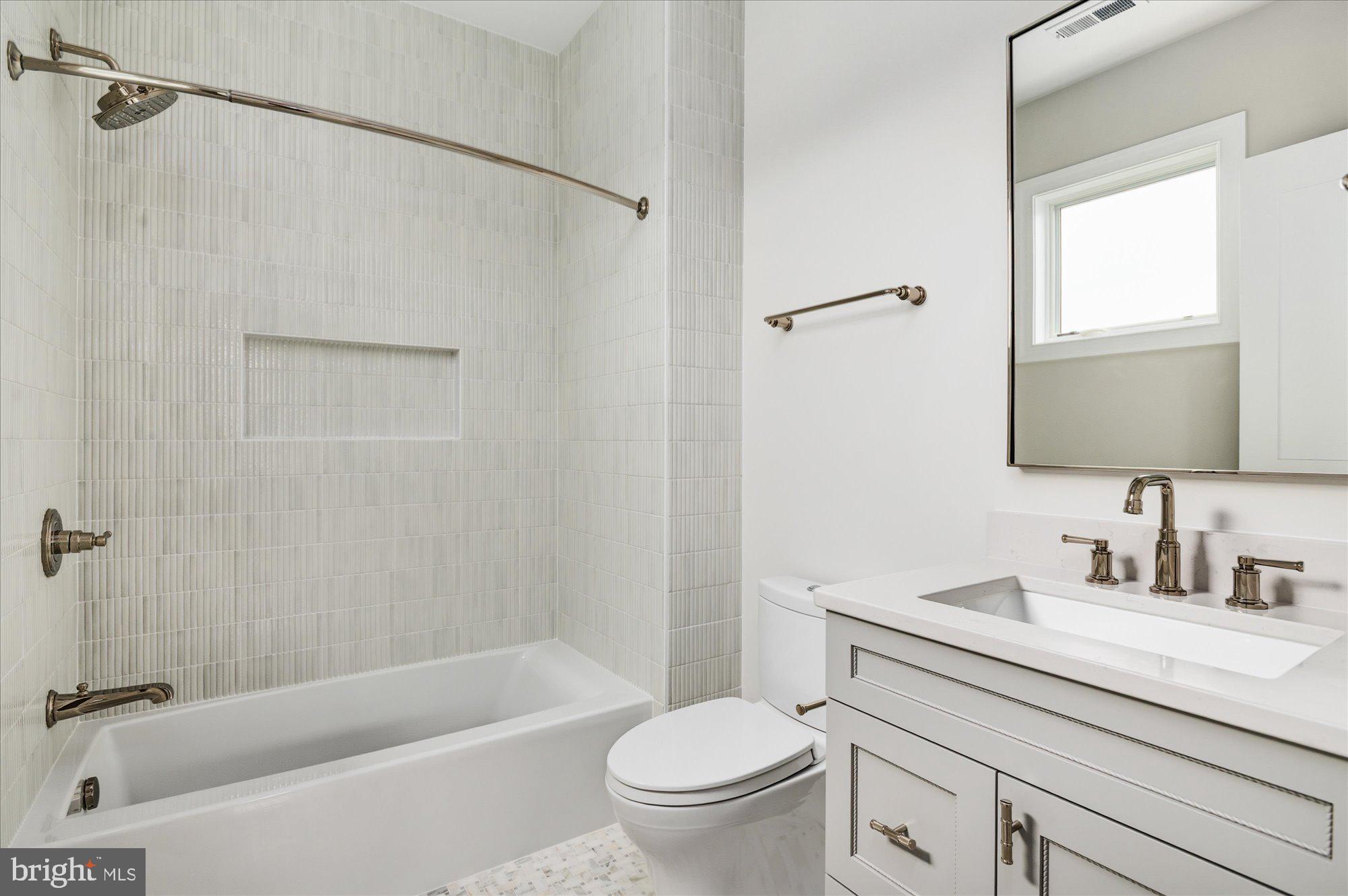 5908 Calla Drive McLean, VA 22101 - Photo 50 of 66 a bathroom with a sink a mirror a toilet and a bathtub