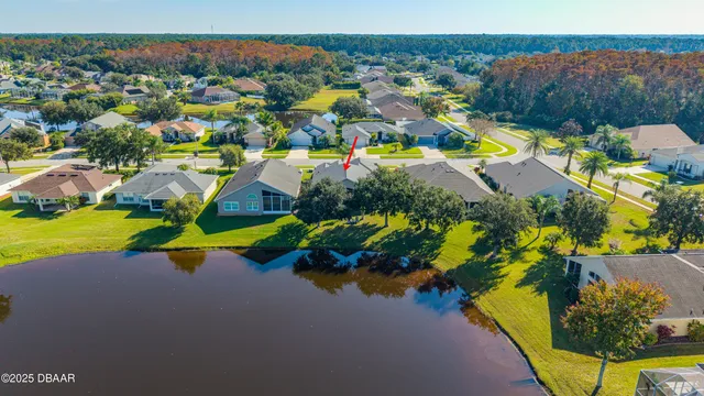 an aerial view of residential house with yard and ocean view