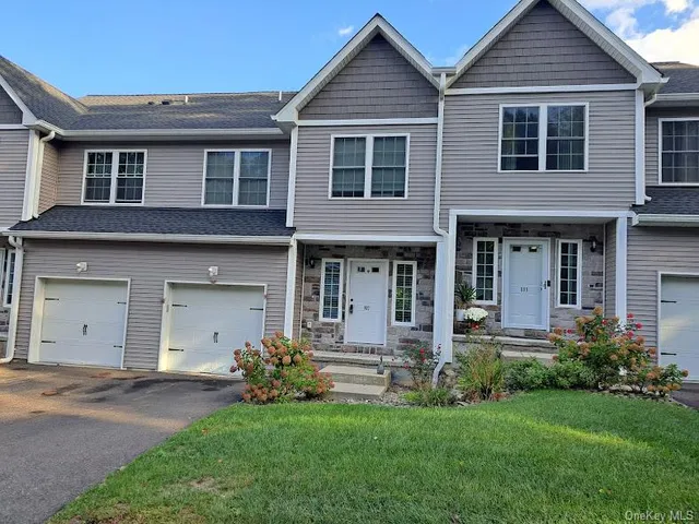 a front view of a house with a garden and plants