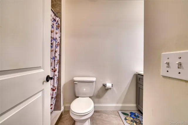 a white toilet sitting next to a shower curtain