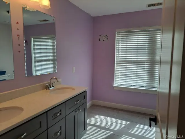 a bathroom with a sink a mirror and a window