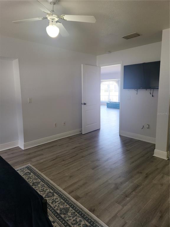 26270 Explorer Road Punta Gorda, FL 33983 - Photo 15 of 22 an empty room with wooden floor cabinet and windows