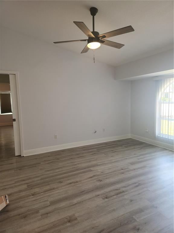 26270 Explorer Road Punta Gorda, FL 33983 - Photo 16 of 22 an empty room with wooden floor fan and windows