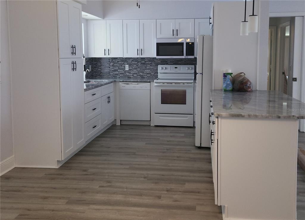 26270 Explorer Road Punta Gorda, FL 33983 - Photo 3 of 22 a kitchen with stainless steel appliances granite countertop a stove a sink and a refrigerator