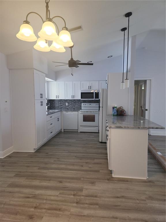 26270 Explorer Road Punta Gorda, FL 33983 - Photo 4 of 22 a large kitchen with cabinets wooden floor and stainless steel appliances