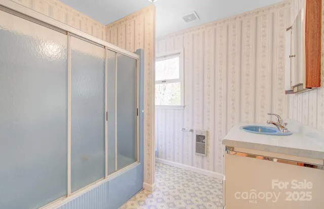 a bathroom with a sink a toilet a mirror and a shower