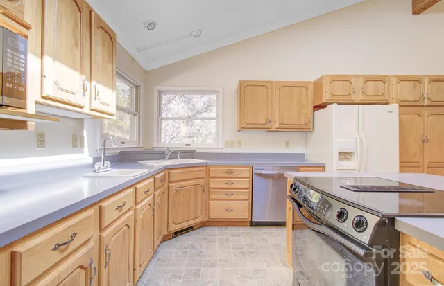 a kitchen with stainless steel appliances granite countertop a sink stove and cabinets