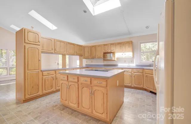 a kitchen with granite countertop a refrigerator sink and cabinets