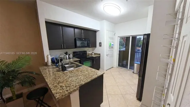 a kitchen with kitchen island a counter top space cabinets and stainless steel appliances