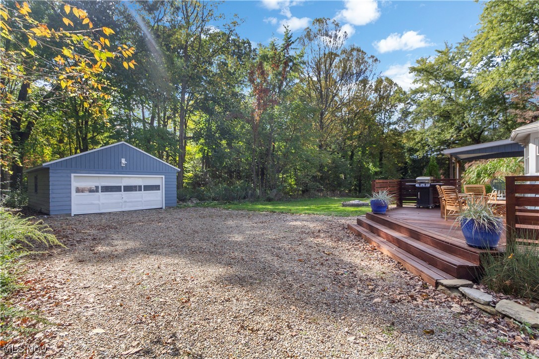 4694 Heather Hills Road Akron, OH 44333 - Photo 25 of 32 View of yard with a garage, a wooden deck, and an outbuilding