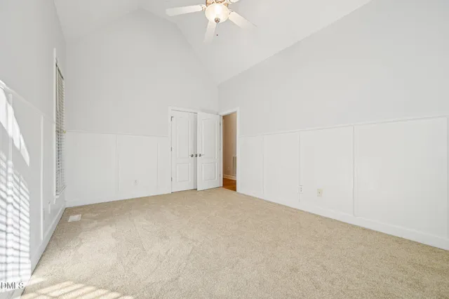 an empty room with a ceiling fan and a window