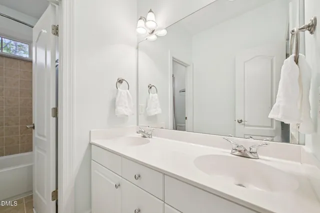 a bathroom with a double vanity sink a mirror and a shower