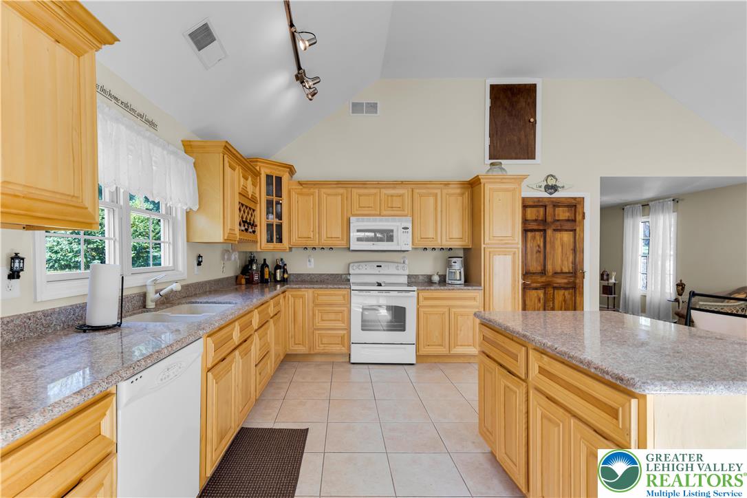 3256 Woodlea Road Orefield, PA 18069 - Photo 25 of 43 a large kitchen with granite countertop a large counter top and appliances