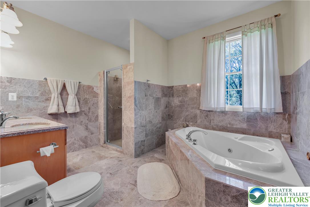 3256 Woodlea Road Orefield, PA 18069 - Photo 35 of 43 a white toilet sitting next to a bathroom sink and tub