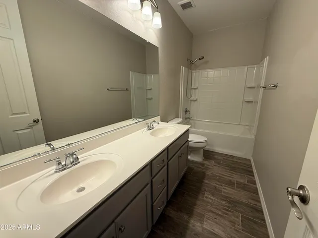 a bathroom with a double vanity sink and mirror with shower