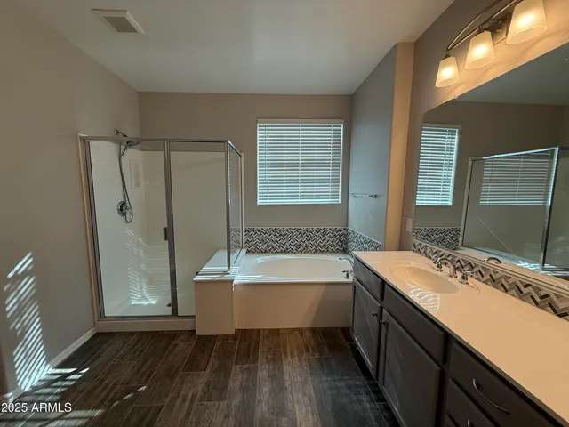 a bathroom with a tub sink and mirror