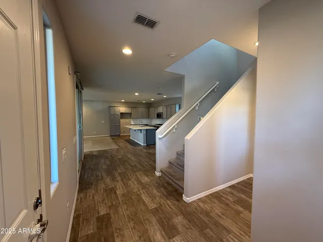 a view of a hallway with wooden floor and staircase