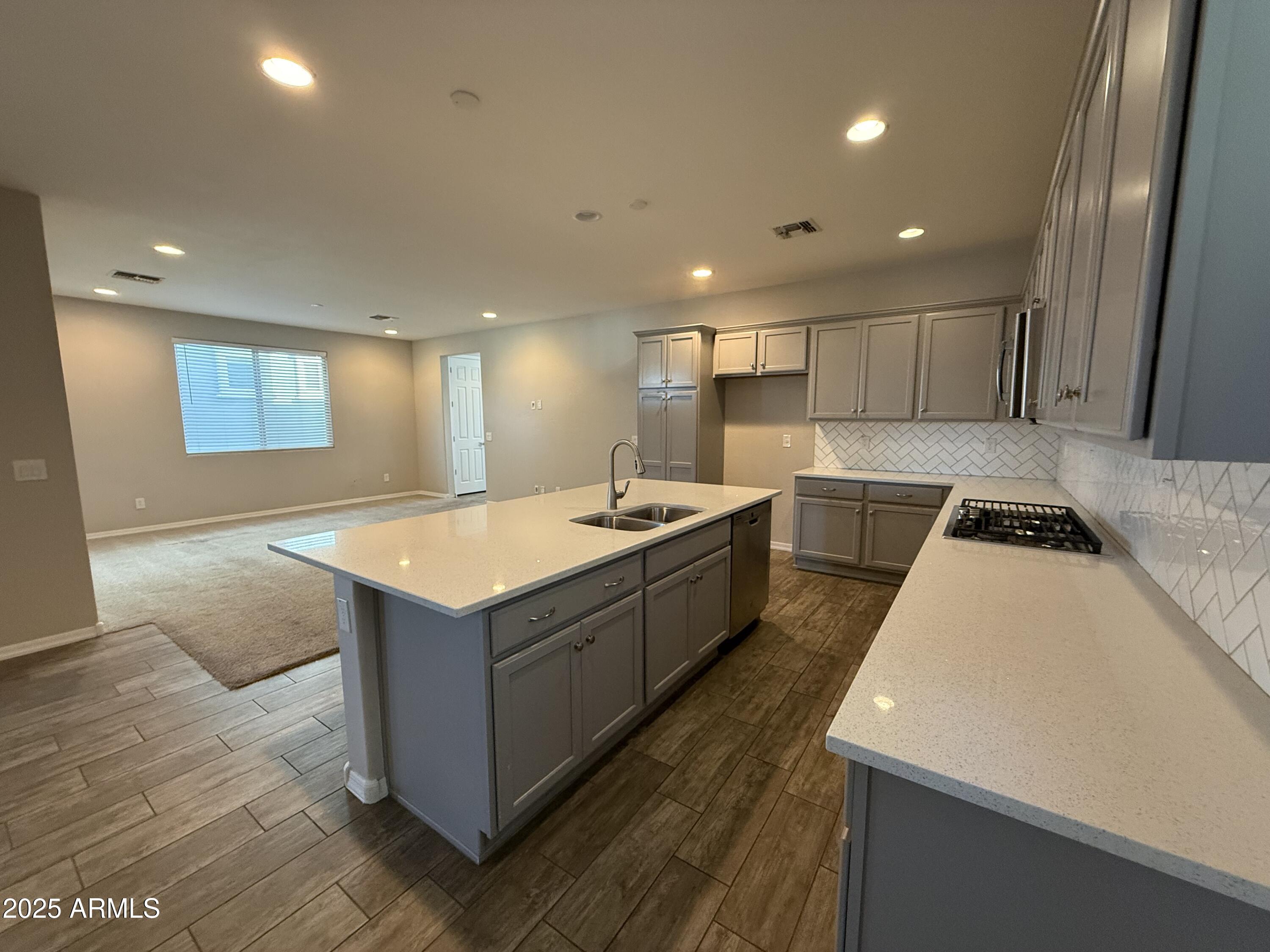 3786 East Robert Street Gilbert, AZ 85295 - Photo 6 of 22 a large kitchen with stainless steel appliances a large counter top a stove and a refrigerator