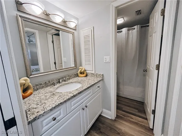 a bathroom with a granite countertop sink and a mirror