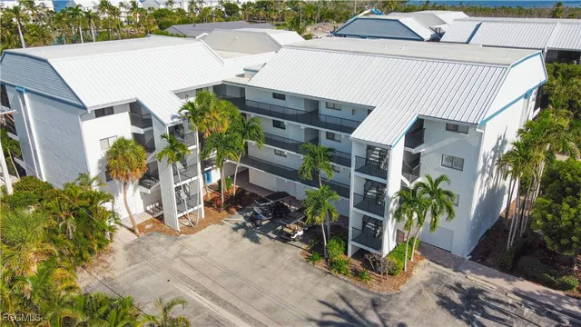 a front view of a building with windows and plants