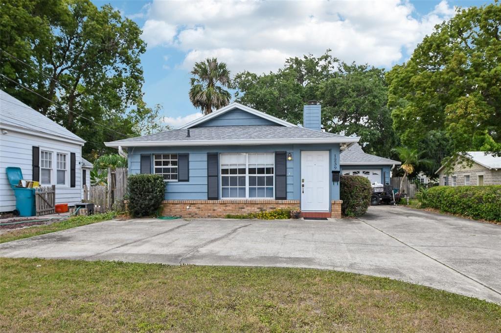 a front view of a house with a yard and potted plants