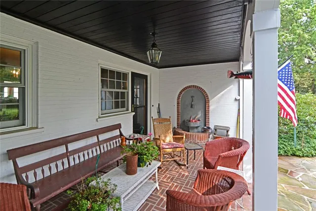 a view of a street with a yard and large trees