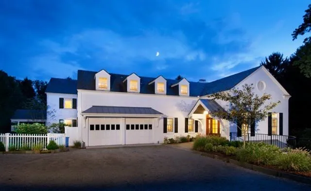 a view of a white house with a big yard and large trees