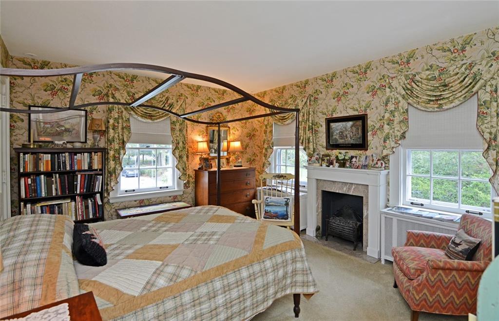 407 Rhodora Lane Pittsburgh, PA 15238 - Photo 43 of 48 a spacious bedroom with a bed a fireplace and a painting on the wall