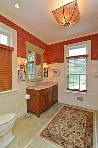 a kitchen with stainless steel appliances granite countertop a stove a sink and white cabinets with wooden floor