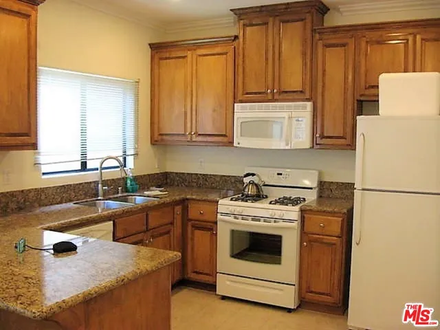 a kitchen with a stove a sink and a refrigerator