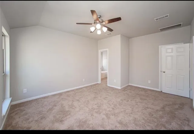 a view of an empty room with a chandelier fan