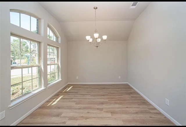 a view of a livingroom with a chandelier fan and windows