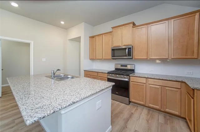 a kitchen with granite countertop wooden cabinets and a granite counter tops